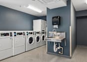 Thumbnail 69 of 75 - A row of washing machines in a laundry room.