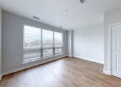 Thumbnail 10 of 18 - A room with a white door and a window with blinds.