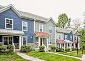 Thumbnail 4 of 18 - A row of houses with the first one having a blue and white facade.