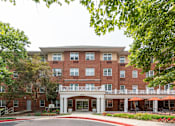 Thumbnail 1 of 18 - a large brick building with trees in front of it