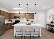 Thumbnail 20 of 25 - A modern kitchen with a white island and bar stools.