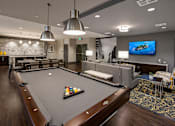 Thumbnail 33 of 33 - A billiard table is in the middle of a room with a TV on the wall.