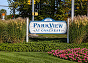 Thumbnail 18 of 19 - A sign for Park View at Oakcrest stands in a field of flowers.