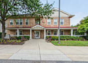 Thumbnail 1 of 14 - A two-story brick house with a front porch.