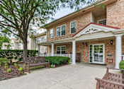 Thumbnail 2 of 14 - A brick house with a porch and a tree in front.