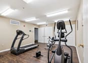Thumbnail 7 of 14 - A home gym with a treadmill, elliptical trainer and a stationary bike.