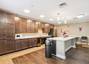 Thumbnail 3 of 14 - A kitchen with wooden cabinets and a white counter.