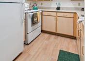 Thumbnail 10 of 14 - A kitchen with wooden cabinets and a white refrigerator.