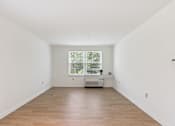 Thumbnail 8 of 14 - A room with wooden floors and a window.
