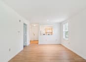 Thumbnail 11 of 14 - A white room with a wooden floor and a window.