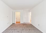 Thumbnail 12 of 14 - A room with a carpeted floor and two doors.