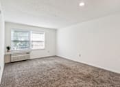 Thumbnail 18 of 21 - A room with a window and a carpeted floor.