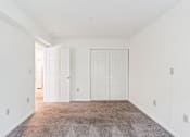 Thumbnail 16 of 21 - A room with white walls and a carpeted floor.