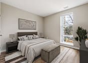 Thumbnail 14 of 17 - A bedroom with a large bed and a window overlooking a tree-lined street.