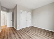 Thumbnail 16 of 17 - A room with a wooden floor and white walls.