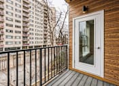 Thumbnail 9 of 17 - A balcony with a white door and a black railing.