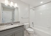 Thumbnail 21 of 22 - A white bathroom with a sink, toilet, and bathtub.