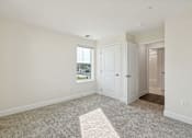 Thumbnail 20 of 22 - A room with a carpeted floor and a window.