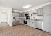Thumbnail 9 of 22 - A kitchen with wooden floors and stainless steel appliances.