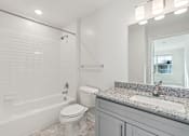 Thumbnail 14 of 22 - A white bathroom with a sink, toilet, and bathtub.