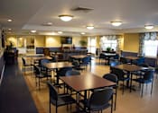Thumbnail 3 of 13 - A large community room with tables and chairs.
