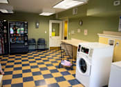 Thumbnail 5 of 13 - Laundry room with a washer, dryer, and vending machine.