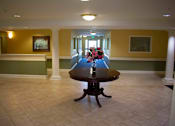 Thumbnail 9 of 13 - A vast hallway with a display table and colorful flowers