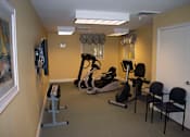 Thumbnail 10 of 13 - A fitness room fully equipped with a treadmill, exercise bike, and a television.