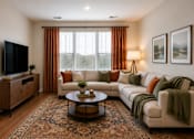 Thumbnail 14 of 18 - A living room with a large couch, a coffee table, and a television.