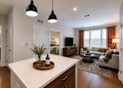 Thumbnail 15 of 18 - A modern kitchen with a white countertop and wooden cabinets.