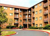 Thumbnail 2 of 9 - Mid-rise apartment building at College Parkway Place featuring elevator access, controlled entry, off-street parking, and landscaped grounds in the heart of Annapolis, MD.