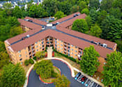 Thumbnail 3 of 9 - Mid-rise apartment building at College Parkway Place featuring elevator access, controlled entry, off-street parking, and landscaped grounds in the heart of Annapolis, MD.