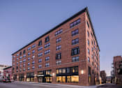 Thumbnail 32 of 33 - A large red brick building with many windows is shown.