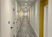 Thumbnail 13 of 30 - Well-lit hallways and interior apartment home entry at Metro Heights in Baltimore.