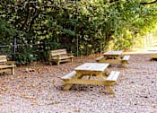 Thumbnail 14 of 15 - Welcome outdoor courtyard with tables, benches and bean bag toss at Park Montgomery apartments located along the Purple Line in Silver Spring, MD.