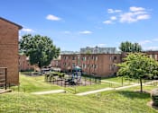 Thumbnail 11 of 19 - Exterior view of Meadowbrook Run Apartments, an Enterprise community in Congress Heights, Washington, D.C., surrounded by mature trees and green space, showcasing a peaceful park-like setting.