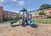 Thumbnail 12 of 19 - On-site playground at Meadowbrook Run Apartments in Congress Heights, Washington, D.C., featuring safe, modern play structures surrounded by green space—offering a fun and active outdoor area for children and families in the community.