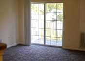 Thumbnail 4 of 8 - A room with a sliding glass door leading to a backyard.