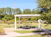Thumbnail 5 of 8 - A flag pole with the American flag flying in front of a white archway.