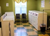 Thumbnail 14 of 15 - On-site laundry facility at Park View at South Pantops, featuring multiple washers and dryers in a clean, well-lit space for the convenience of senior residents age 62 and better.