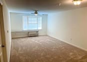 Thumbnail 9 of 15 - Spacious living room inside a 2-bedroom apartment at Park View at South Pantops, featuring wall-to-wall carpet, large windows with natural light, and individually controlled heating and air conditioning.