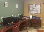 Thumbnail 6 of 11 - a computer room with three desks with computers and chairs