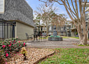 Thumbnail 4 of 10 - A courtyard with a fountain, benches, and trees.