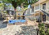 Thumbnail 3 of 10 - A patio with a stone floor and a blue couch.