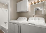 Thumbnail 9 of 10 - A white washing machine and dryer in a laundry room.