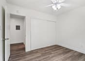 Thumbnail 18 of 35 - A room with a ceiling fan and wooden flooring.