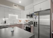 Thumbnail 9 of 43 - A modern kitchen with stainless steel appliances and a central island.