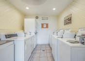 Thumbnail 32 of 35 - A laundromat with washers and dryers is clean and empty.