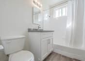 Thumbnail 26 of 35 - A white bathroom with a toilet, sink, and mirror.