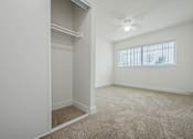 Thumbnail 21 of 35 - A room with a window and a carpeted floor.